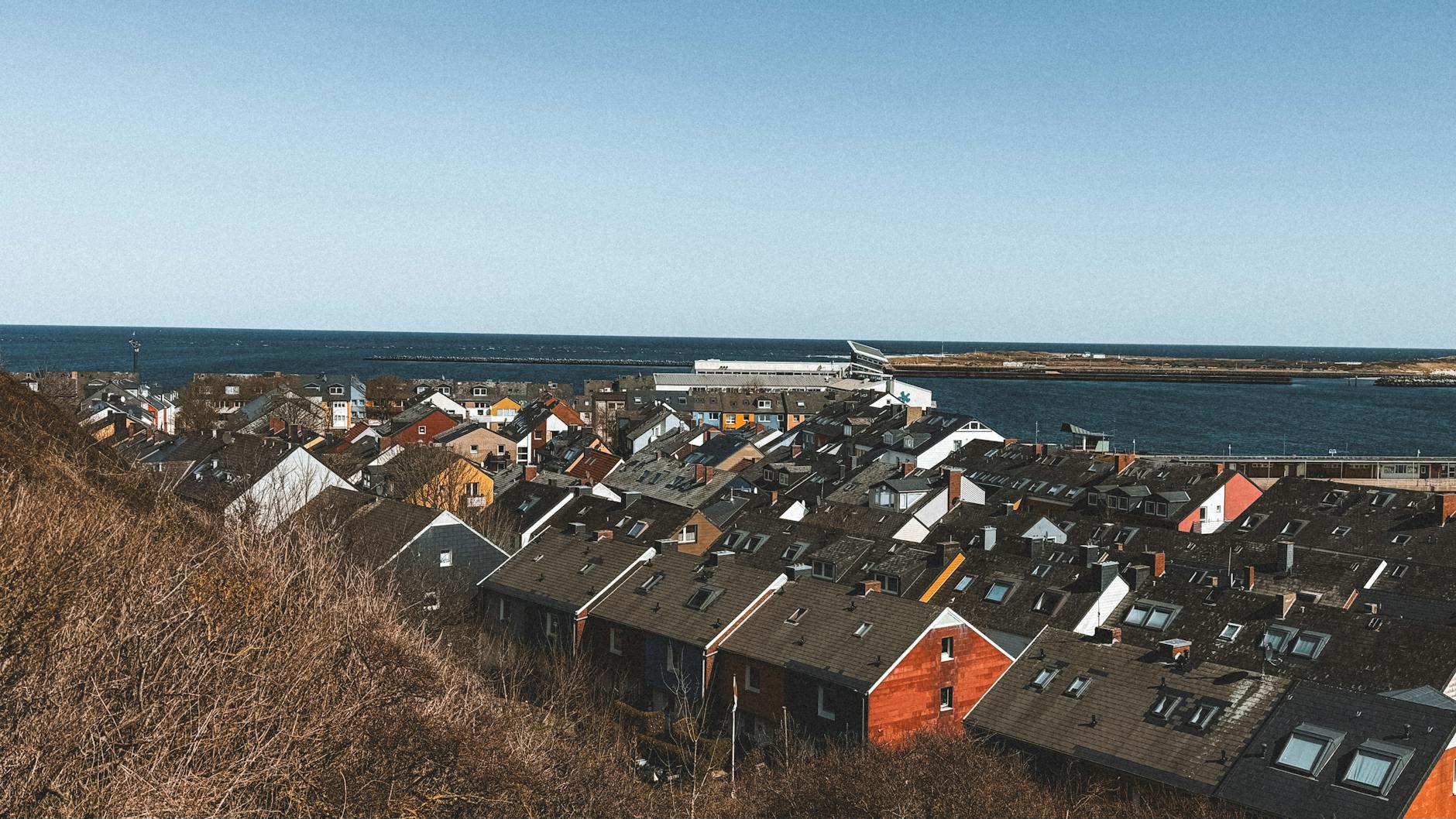 Kolorowe domy nad morzem w Helgolandzie przy skalistym wybrzeżu