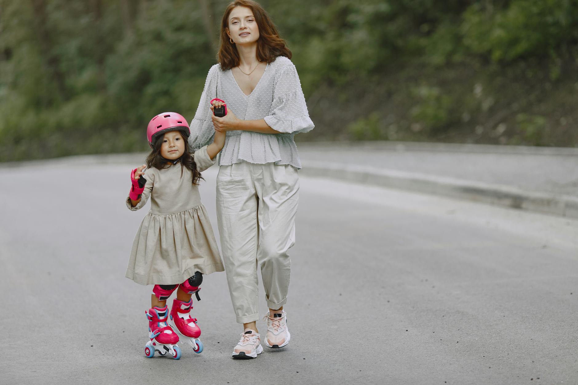 Jak zacząć jeździć na rolkach po 30. roku życia: praktyczny przewodnik dla zapracowanych Mama uczy córkę jazdy na rolkach na spokojnej, malowniczej drodze